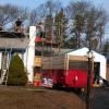 Old painted block chimney being torn down and loaded into dump trailer